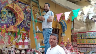 مسيحي يشتري فوانيس وزينة رمضان ويعلقها في أحد شوارع أسوان