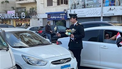 رجال مرور الدقهلية يوزعون الورود والأعلام على المواطنين احتفالا بعيد الشرطة