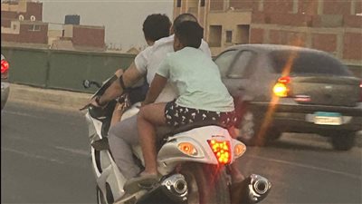 بالصور.. مواطن يعرض حياة طفليه للخطر من أعلى دراجة نارية ويسير دون لوحات معدنية
