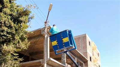 بالصور.. تركيب وصيانة كشافات أعمدة الإنارة الكهربائية بمركز الطود في الأقصر
